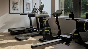 Gimnasio con cintas de correr, bicicletas estáticas y una máquina de remo.