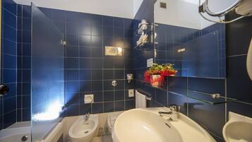 A bathroom with a bathtub, two sinks, and a glass shower enclosure.
