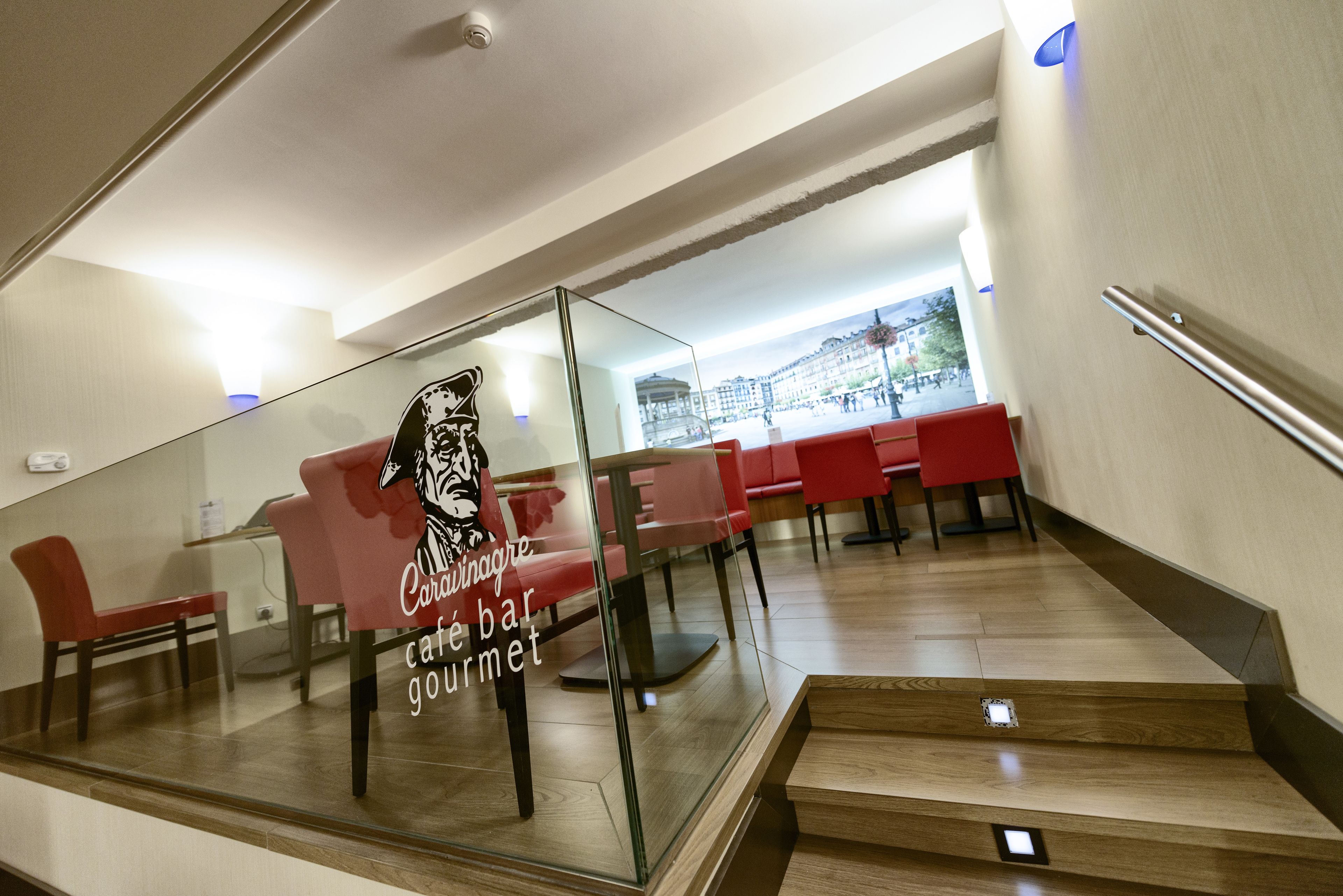 A modern interior with a glass wall displaying a sign for "Caravane café bar gourmet."