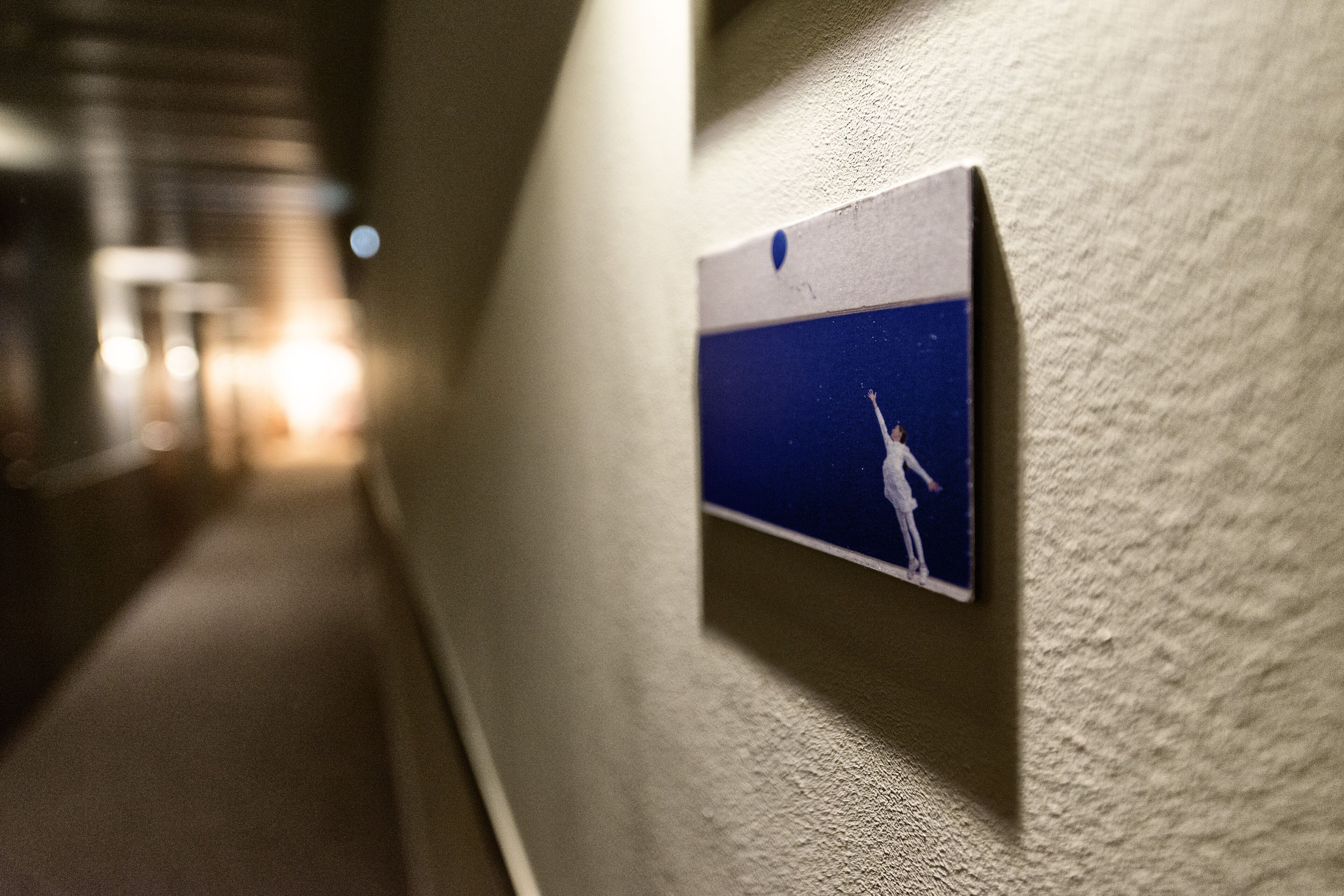 A corridor with a wall-mounted sign featuring a person reaching for a star.