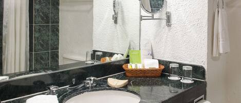 A bathroom with a black marble sink, a large mirror, and a towel rack.
