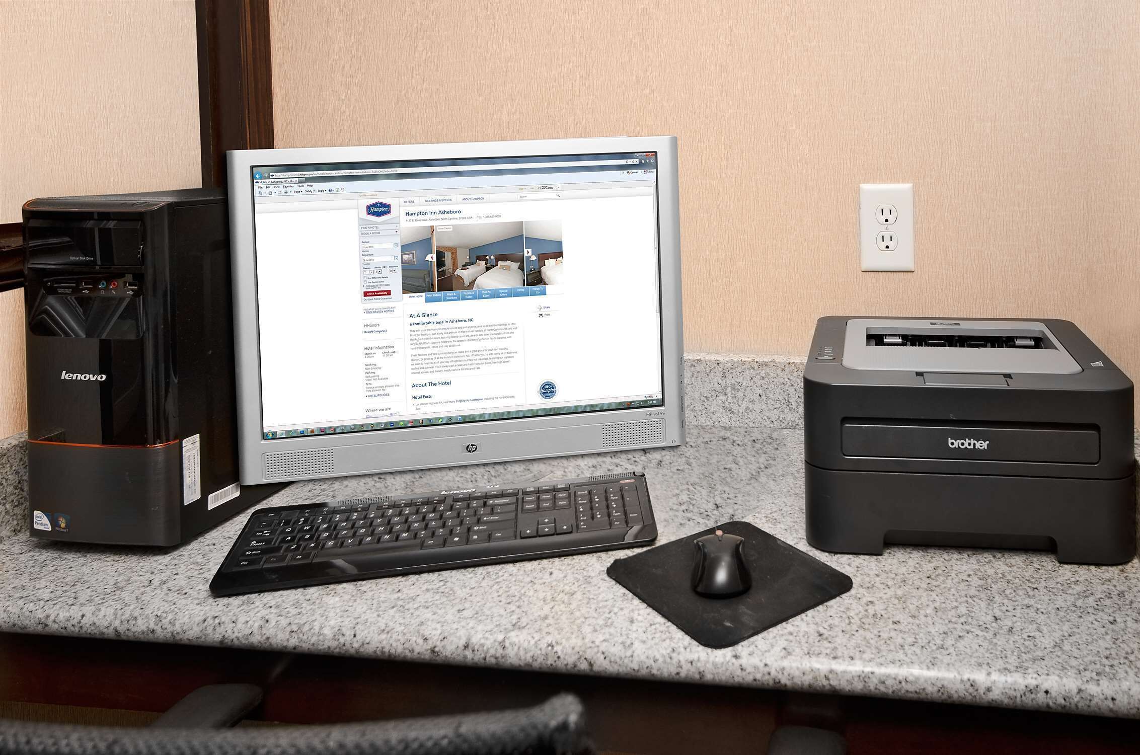 A desktop computer with a monitor, keyboard, and mouse on a granite countertop.