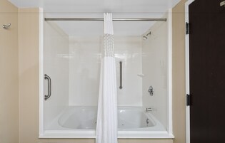 Un baño moderno con ducha envuelta en vidrio y bañera independiente.