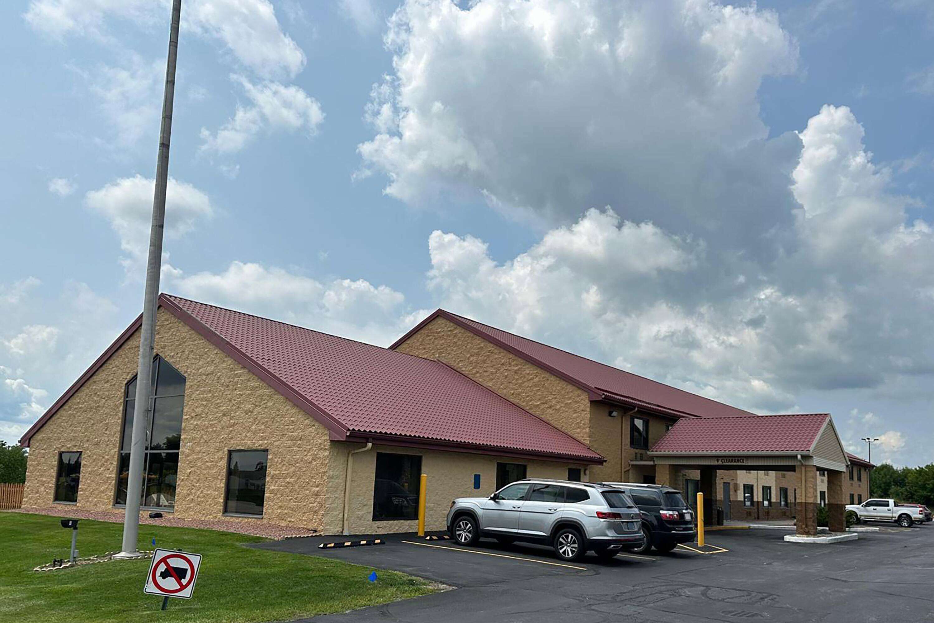 A building with a red roof and a sign indicating no parking.