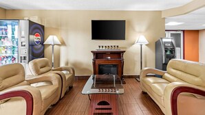 A hotel room with leather sofas, a glass coffee table, a fireplace, a flat-screen TV, and vending machines. - Super 8 by Wyndham Sturtevant/Racine (Sturtevant)