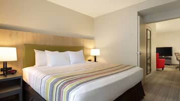 Habitación de hotel con una cama grande, dos lámparas de noche, un escritorio con una silla y un televisor.