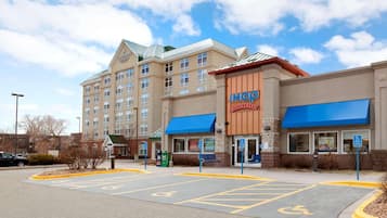 A hotel with a large building and a smaller structure with a blue awning.