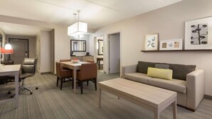 A modern hotel room with a dining area, a sofa, and a coffee table.