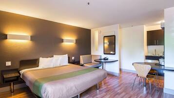 Ein modernes Hotelzimmer mit einem großen Bett, Nachttischen, einem Schreibtisch und einem Sessel.