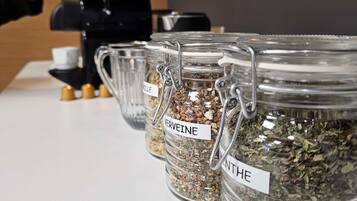 A coffee station with labeled containers of coffee grounds.