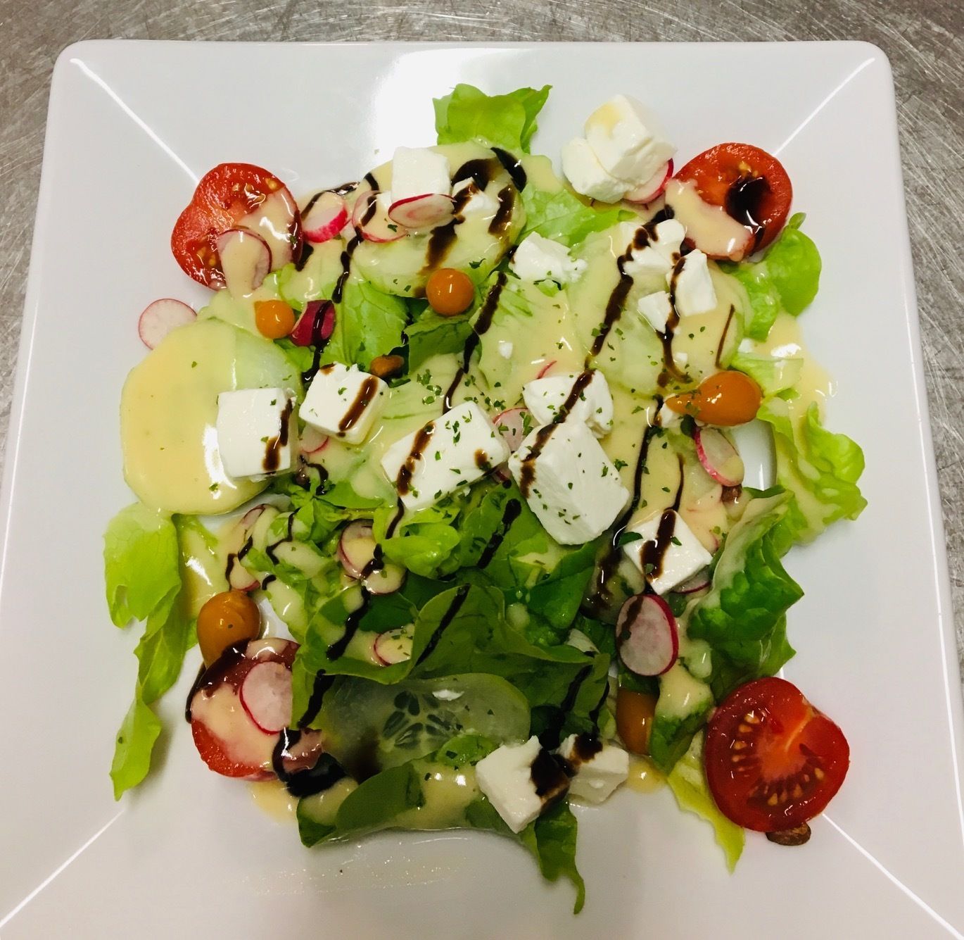 Een bord met een salade en diverse ingrediënten.