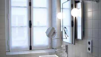 A modern bathroom with a large window, a white sink, and a mirror.