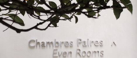 A wall with the text "Chambres Palais Even Rooms" indicating the name of the hotel or establishment.