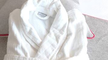 A neatly folded white bathrobe with a visible label on the inside.