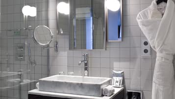 Un baño con lavamanos de mármol, un espejo y un perchero para toallas.