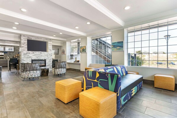 Relax in a spacious living area with a comfortable sofa, matching ottomans, and a flat-screen TV.