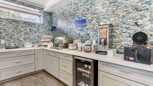 A kitchen with a unique mosaic backsplash, a built-in dishwasher, and a coffee machine. - Best Western Marina State Beach (Marina)