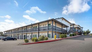 A multi-story motel with balconies, a parking lot, and a fire hydrant. - Best Western Marina State Beach (Marina)