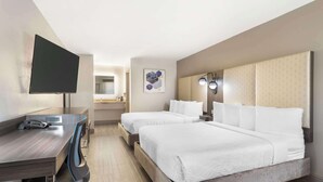 A hotel room with a desk, two beds, a TV, a mirror, and a bathroom in the background. - Best Western Marina State Beach (Marina)