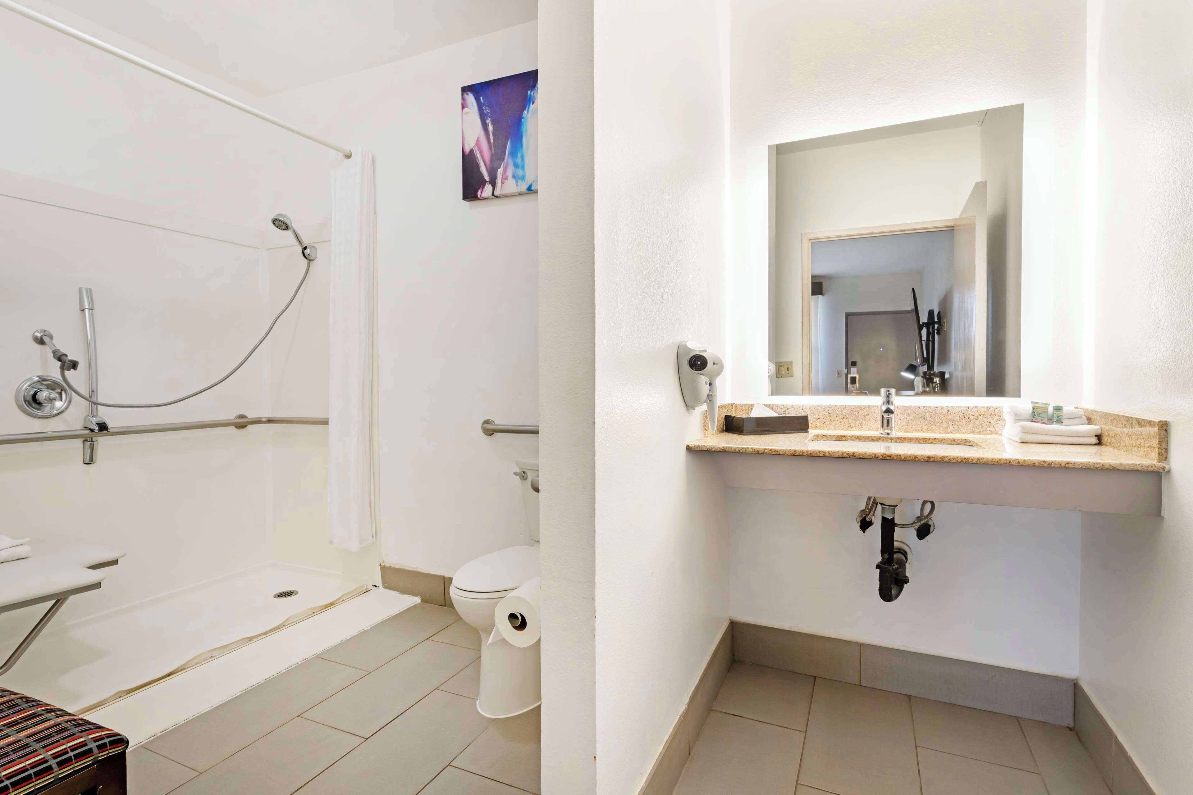 Een badkamer met een douche, toilet en wastafel.