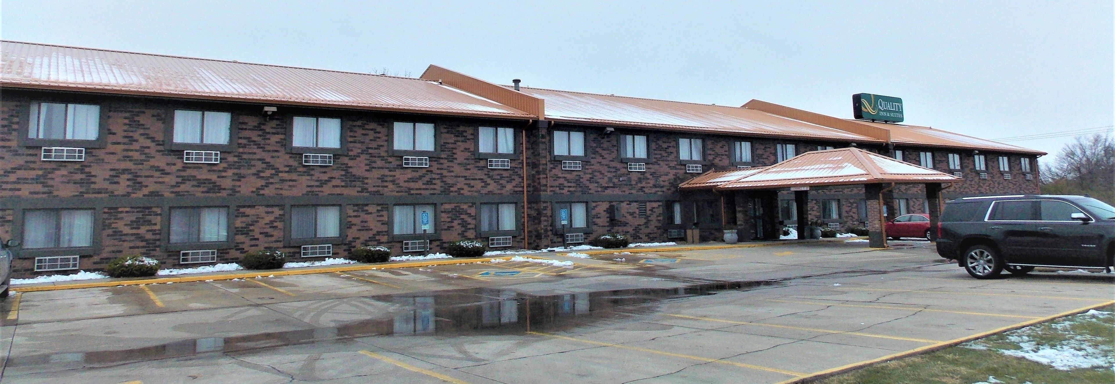 Un edificio de ladrillo con el letrero de Quality Inn & Suites.
