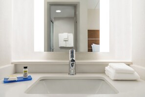 A bathroom with a white sink, a mirror, and a towel rack. - Holiday Inn Express Plattsburgh by IHG (Plattsburgh)
