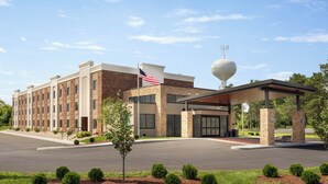 A hotel with a covered entrance, a flag, and a spherical structure on the roof.