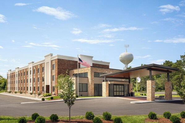 A hotel with a covered entrance, a flag, and a spherical structure on the roof.
