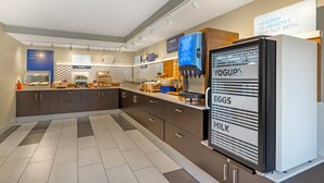 A modern kitchen with a yogurt dispenser, a breakfast bar, and a sign about healthy eating.