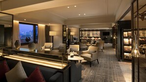 A modern hotel lobby with a seating area, a reception desk, and a view of the cityscape. - Kempinski Hotel Beijing Yansha Center (Beijing)