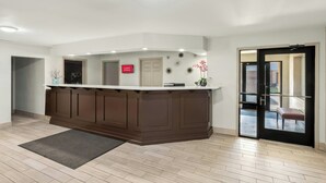 A reception area with a wooden counter, a sign indicating 'Free Wi-Fi Available,' and a door leading outside.