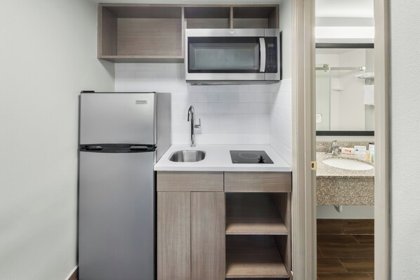 A compact kitchen with a built-in microwave, a refrigerator, a sink, and a countertop. - Red Roof Inn & Suites Marysville (Marysville)