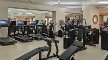 A gym with treadmills, weight machines, and benches.