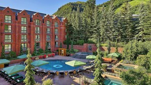 A hotel with a swimming pool, lounge chairs, and a mountainous backdrop. - The St. Regis Aspen Resort (Aspen)
