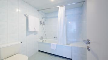 A bathroom with a toilet, a bathtub, and a shower.