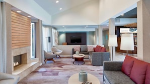 A spacious living area with a fireplace, modern furniture, and a flat-screen TV. - Sonesta Select Raleigh Durham Airport Morrisville (Morrisville)