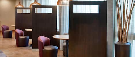 A modern hotel lobby with seating areas, a reception desk, and decorative lighting.