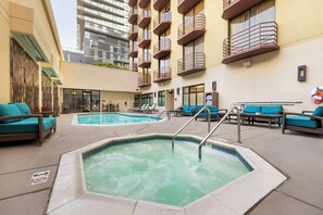 A rooftop pool area with lounge chairs, a hot tub, and a view of a high-rise building. - Best Western Plus Bayside Inn (San Diego)