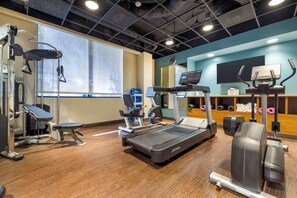 Une salle de sport équipée de tapis de course, d’appareils de musculation et d’autres équipements d’exercice.
