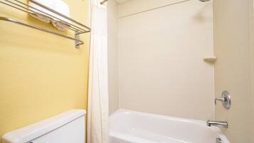 A bathroom with a bathtub, a toilet, and a towel rack.