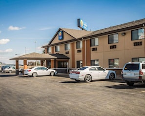 A Comfort Inn hotel with a parking lot, a covered entrance, and a clear blue sky.