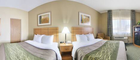 A hotel room with two beds, a nightstand, a lamp, a chair, an air conditioning unit, and a television.