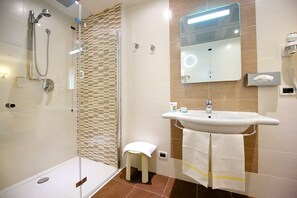 A modern bathroom with a glass-enclosed shower, a sink with a mirror, and a towel rack. - HOTEL STENDHAL (Parma)