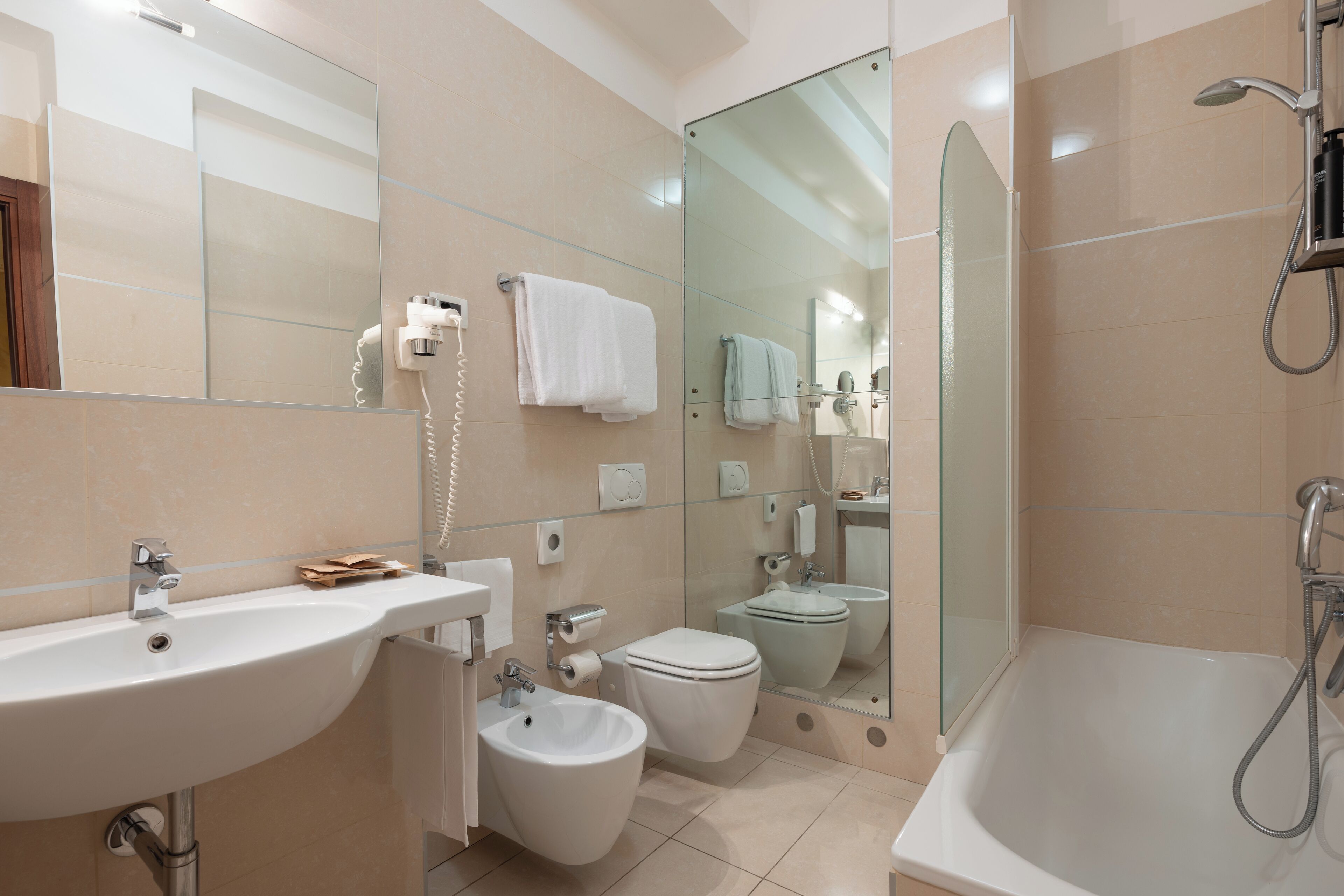 Een moderne badkamer met een wastafel, toilet, bad en bidet.