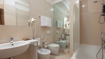 Een moderne badkamer met een wastafel, toilet, bad en bidet.