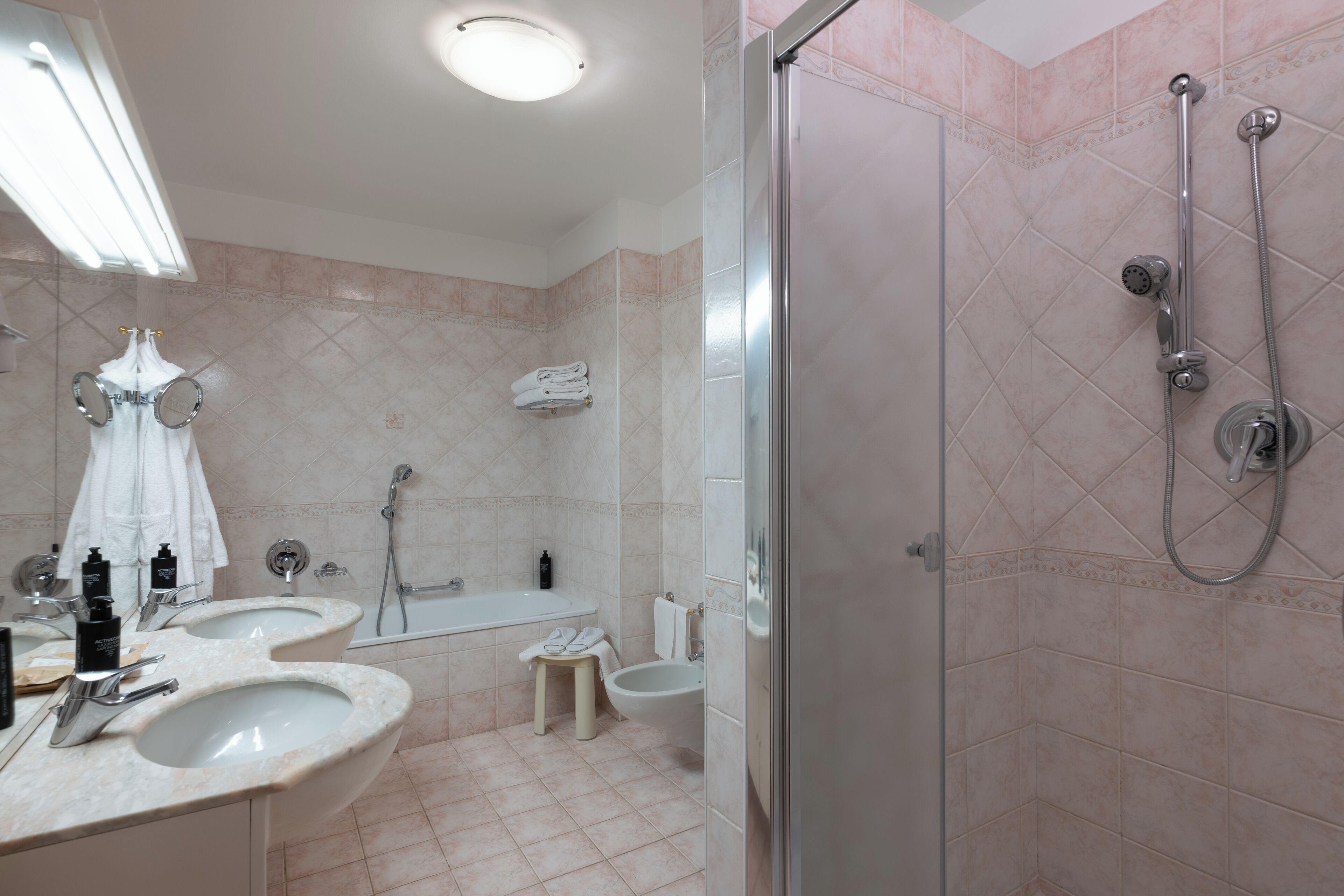 A modern bathroom with two sinks, a bathtub, a shower, and a toilet.