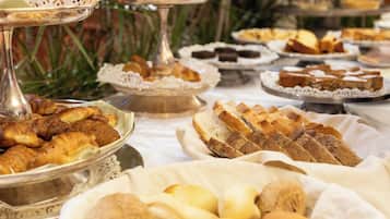 Un buffet con diversi prodotti da forno, tra cui croissant, pane e pasticcini.