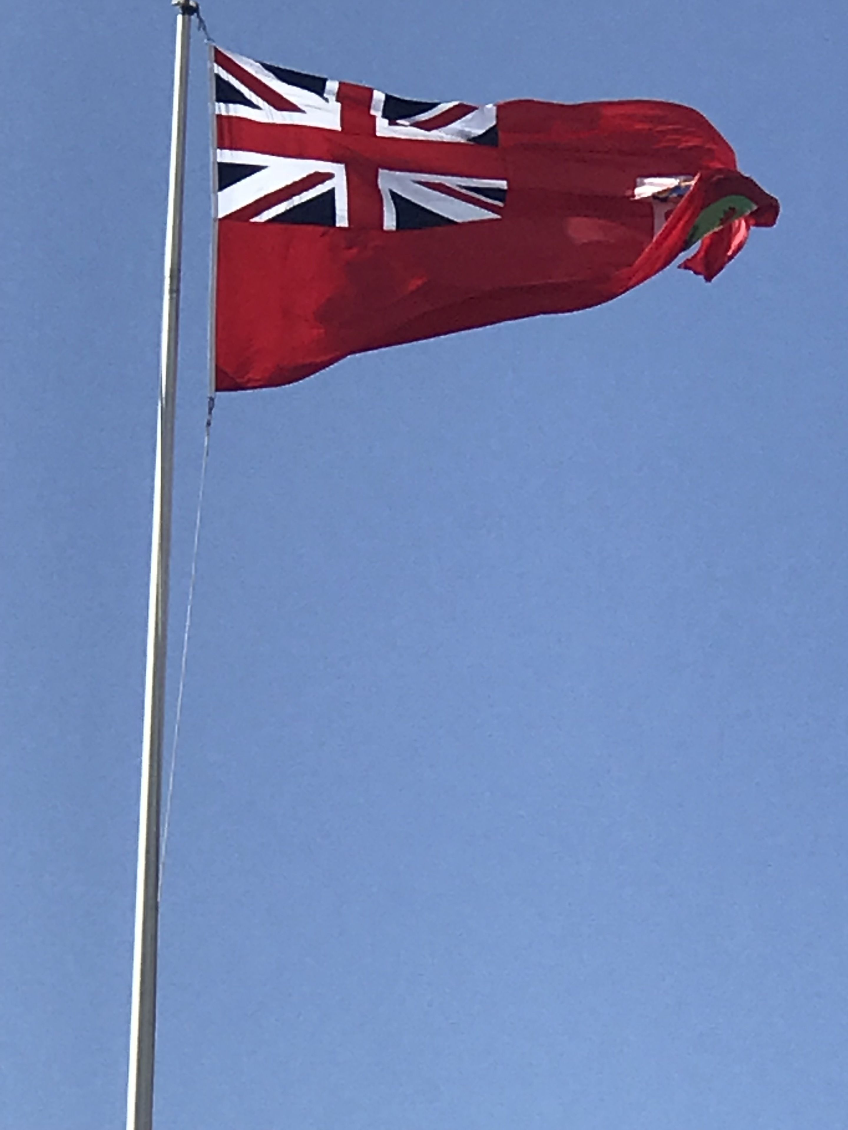A flagpole with a red flag featuring the Union Jack.