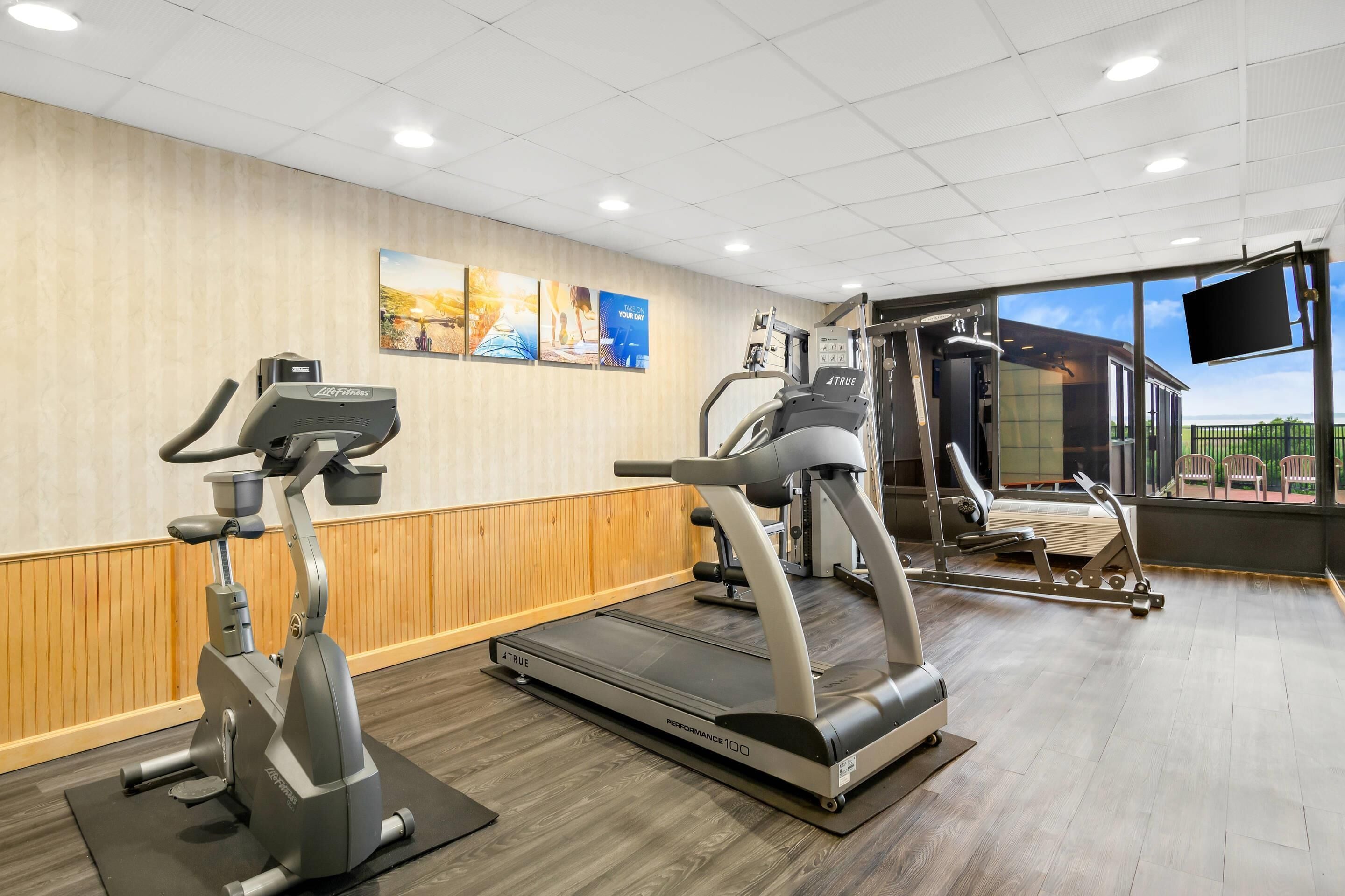 Un gimnasio con bicicletas estáticas, cintas de correr y máquinas de pesas.