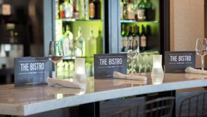 A bar area with two 'The Bistro' signs, glasses, and a candle on a marble counter. - Courtyard by Marriott Richmond/Berkeley (San Pablo)